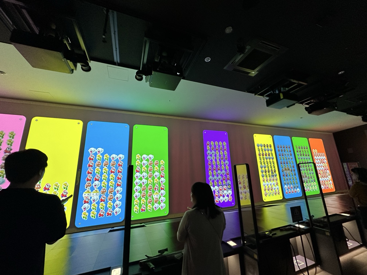 暗闇に光るキャラクターパネル展示 来館者が遊んでいる