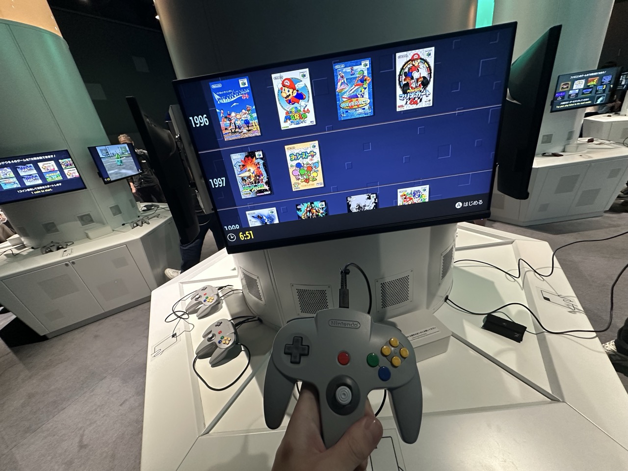 N64の実機コントローラーを手に持って画面のソフト一覧を選ぶ