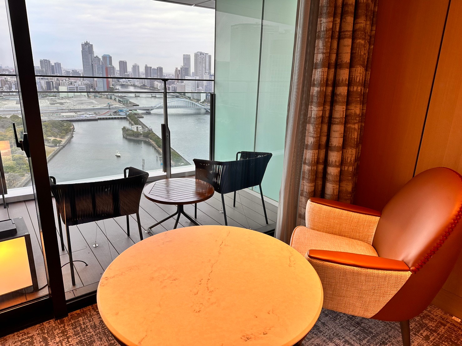 メズム東京 客室とバルコニー 白基調の落ち着いたインテリアと隅田川ビュー