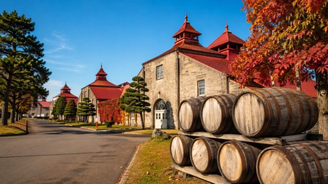 秋の紅葉に包まれたニッカウヰスキー余市蒸溜所の外観とウイスキー樽