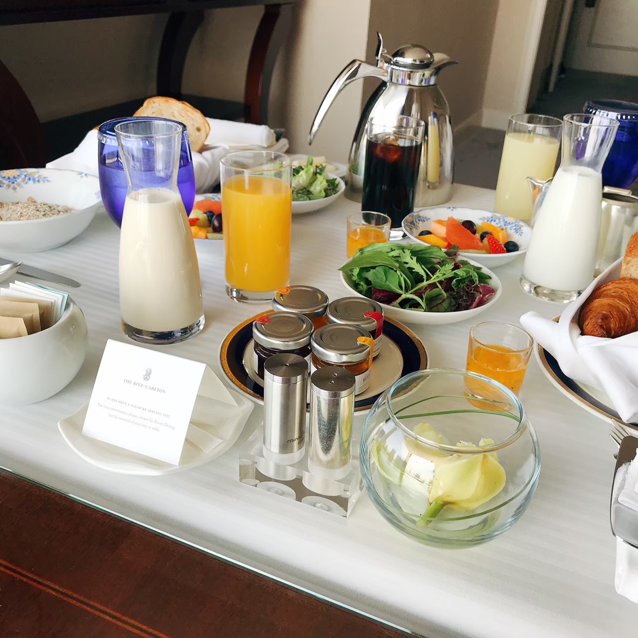 ザ・リッツ・カールトン大阪 朝食のルームサービス — パン・ジュース・フルーツ・シリアル・ミルクピッチャーが並ぶ