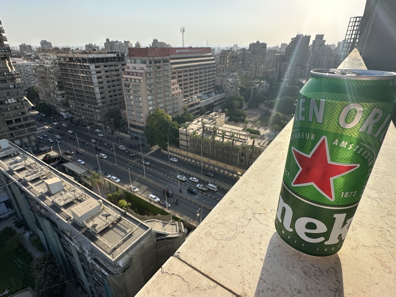 客室バルコニーから市街地ビューとビールの缶 旅の高揚感