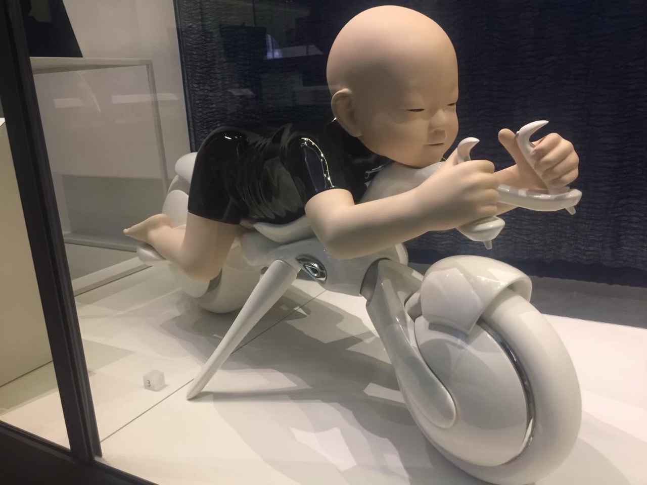 自然史博物館の展示、赤ちゃんがミニ恐竜のオブジェにまたがって遊ぶ