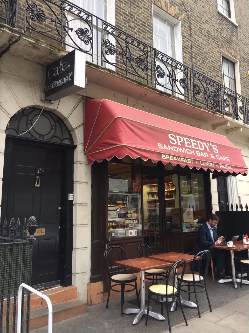 Speedy's Cafe の赤いオーニングと夕方の店構え