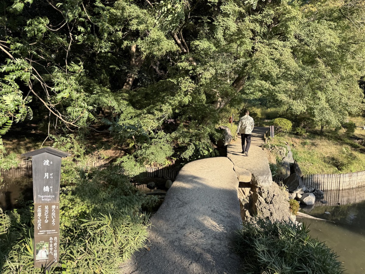 和歌に由来する渡月橋の案内と石橋へ続く園路