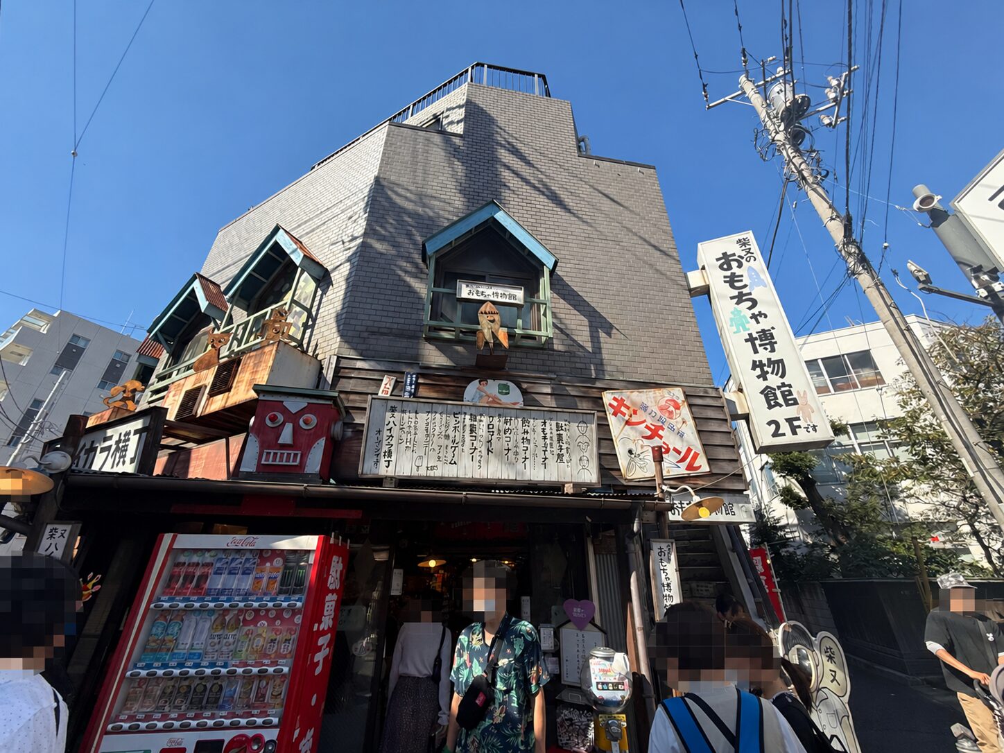 青空の下に建つ柴又ハイカラ横丁と二階の柴又のおもちゃ博物館の入口