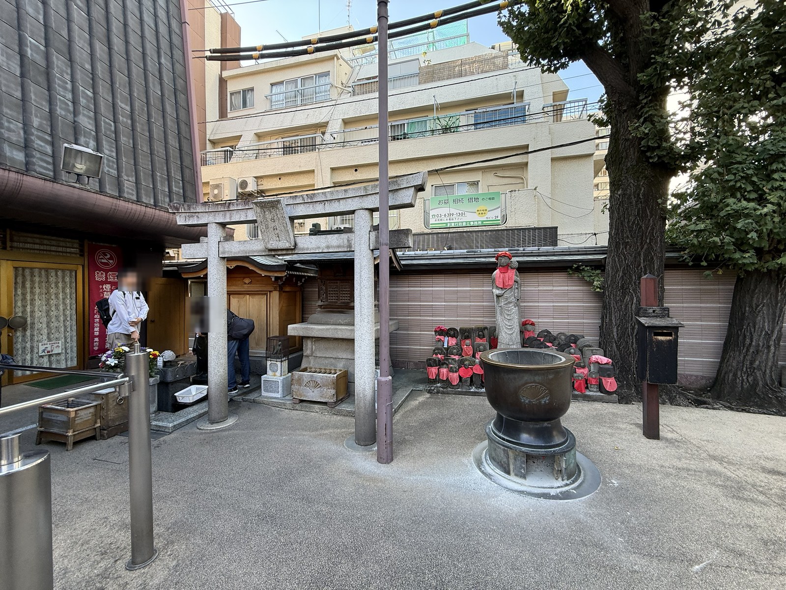 高岩寺境内にある香炉と赤い前掛けを着けた地蔵像