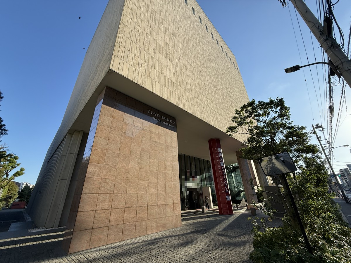 本郷通り側の歩道から見た東洋文庫ミュージアムの建物全体と赤い案内柱